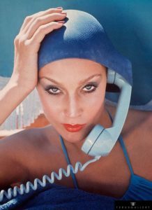 American model Jerry Hall poses with a telephone in Jamaica for British Vogue, 1975.