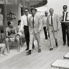 Singer and actor Frank Sinatra, with his minders and his stand in (who is wearing an identical outfirt to him), arriving at Miami beach while filming, 'The Lady in Cement', 1968.