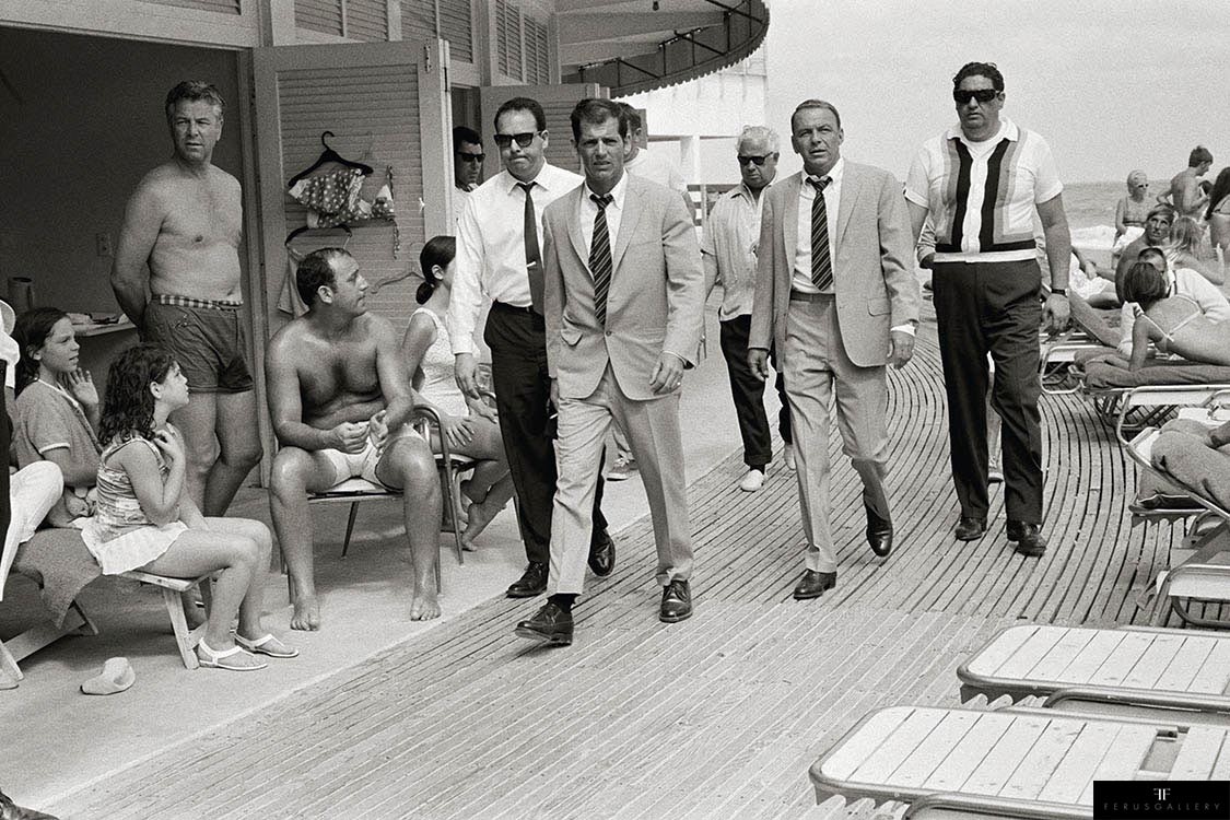 Singer and actor Frank Sinatra, with his minders and his stand in (who is wearing an identical outfirt to him), arriving at Miami beach while filming, 'The Lady in Cement', 1968.