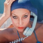 American model Jerry Hall poses with a telephone in Jamaica for British Vogue, 1975.