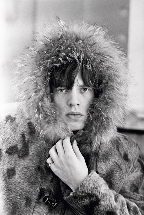 Rolling Stones singer Mick Jagger posing in a fur parka